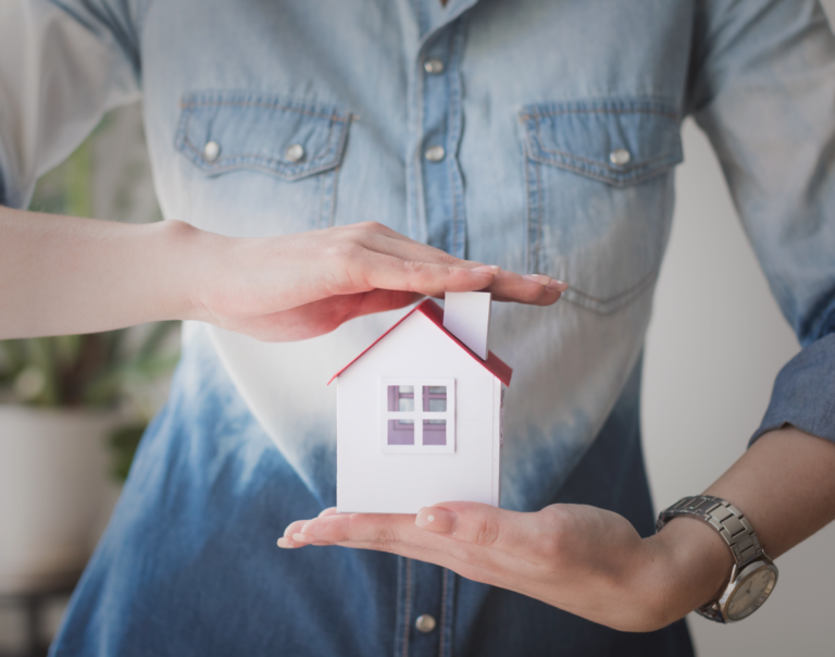 Mujer con una casa de madera entre sus manos. Recoemdaciones al comprar una casa