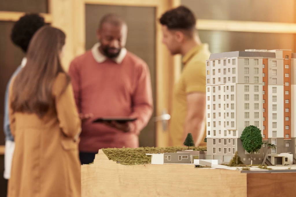 Maqueta, frente a personas decidiendo entre construir o comprar una casa