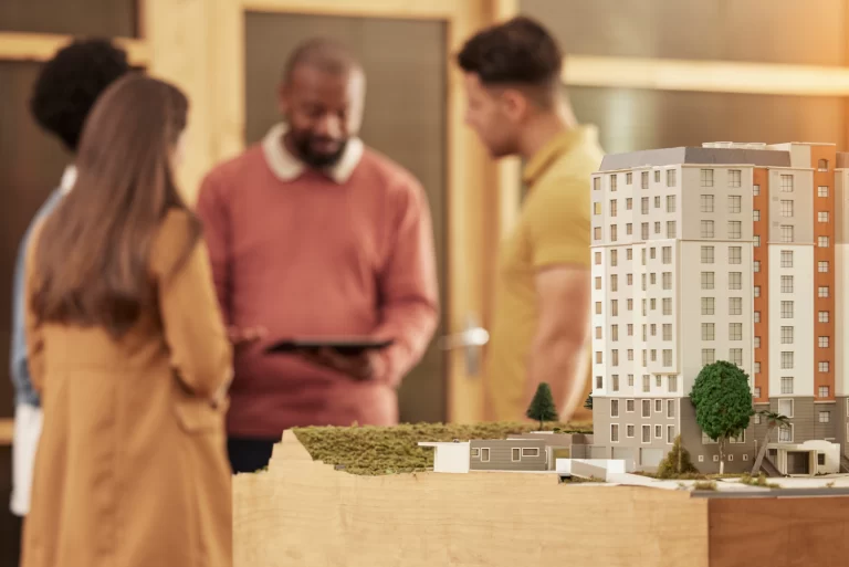 Maqueta, frente a personas decidiendo entre construir o comprar una casa