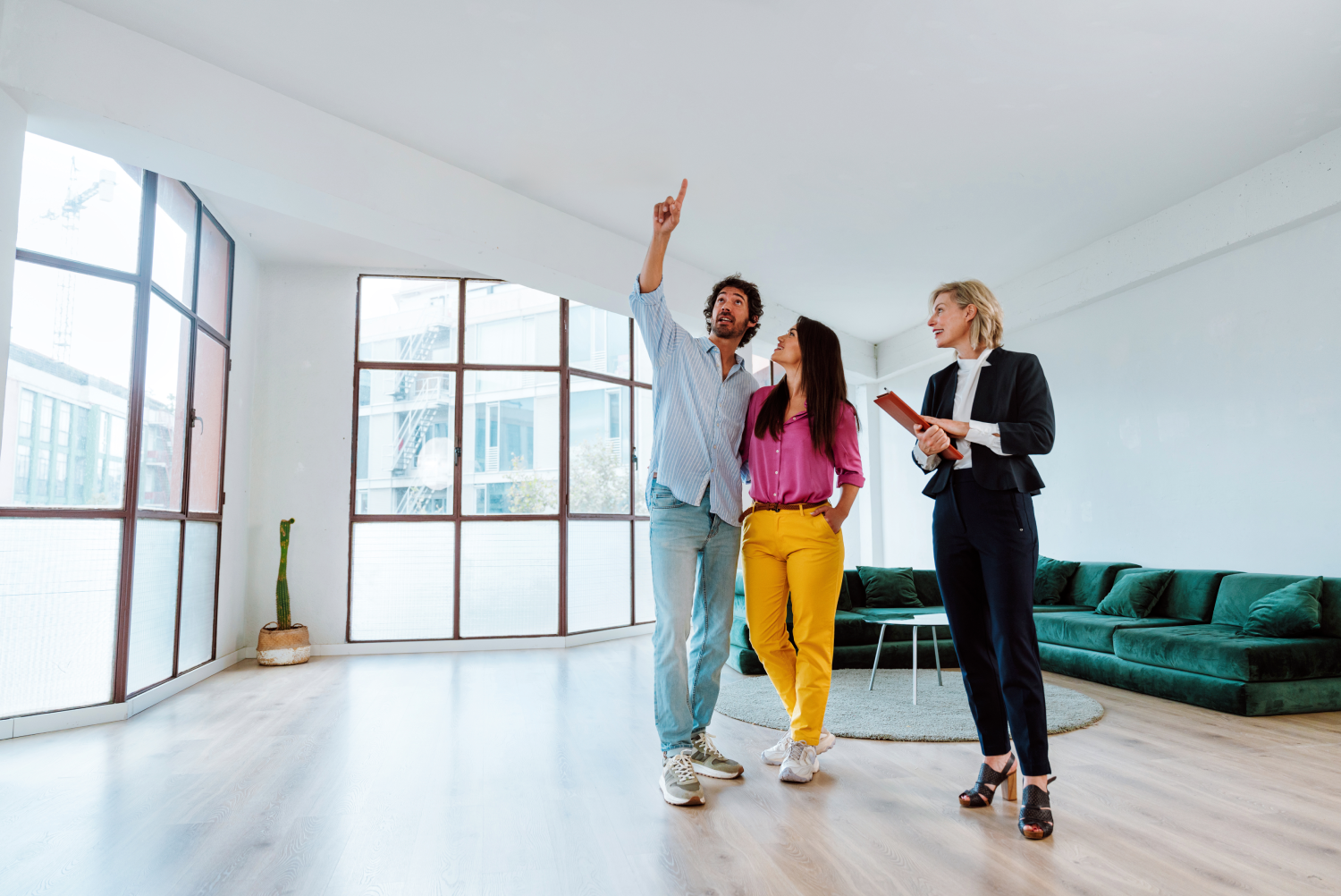 Pareja con una asesora inmobiliaria revisando un departamento