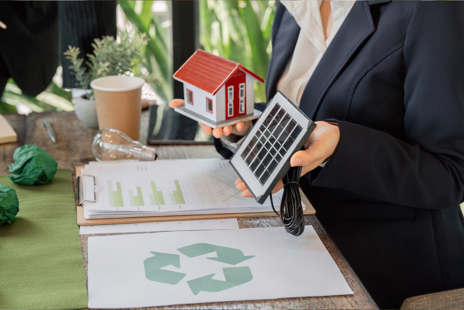 Sosteniendo un panel solar con una casa a lado.