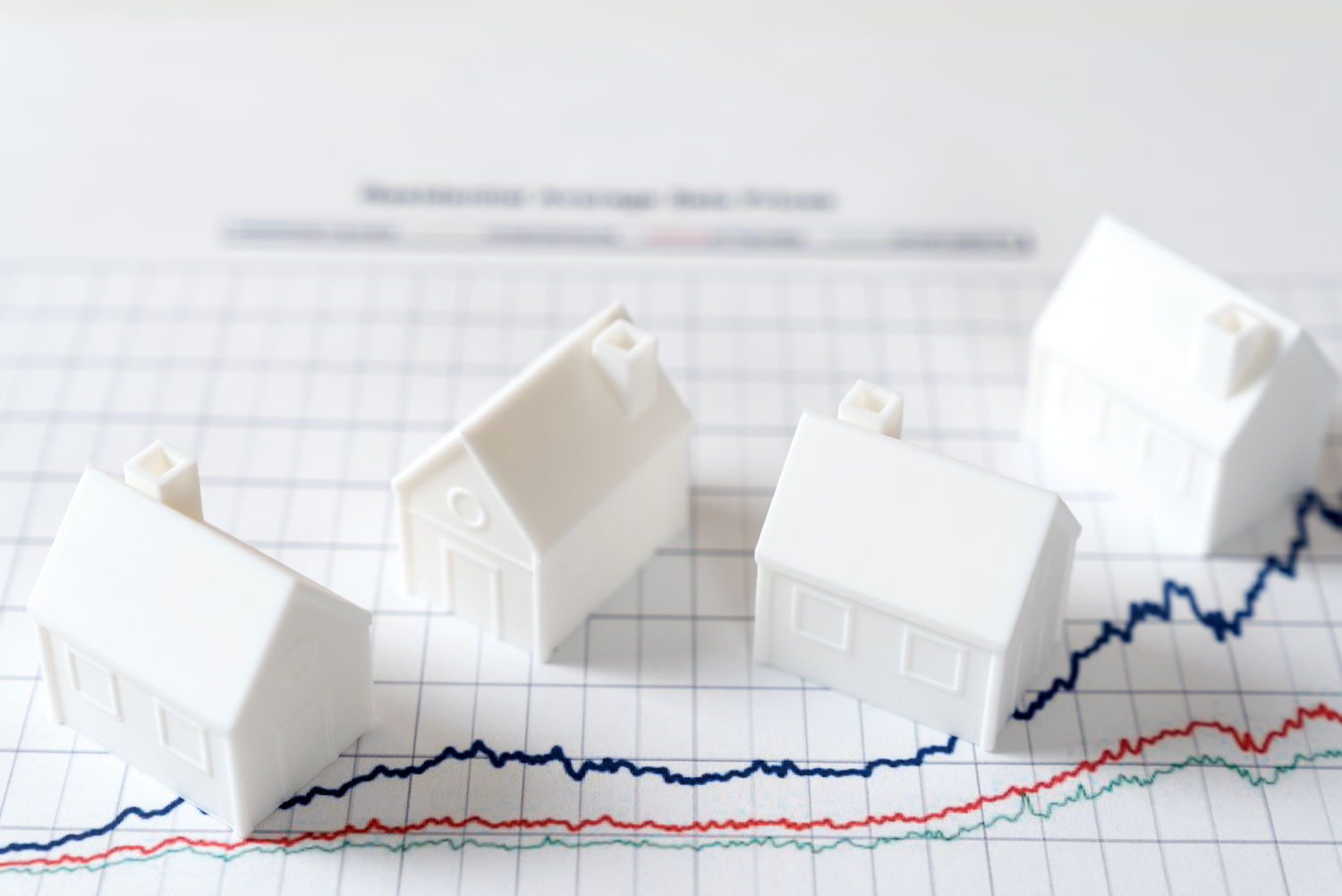 Maqueta de casas arriba de unas gráficas de rendimiento