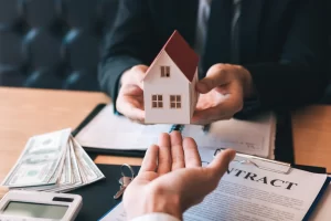 Manos entregando una maqueta de casa a otra mano